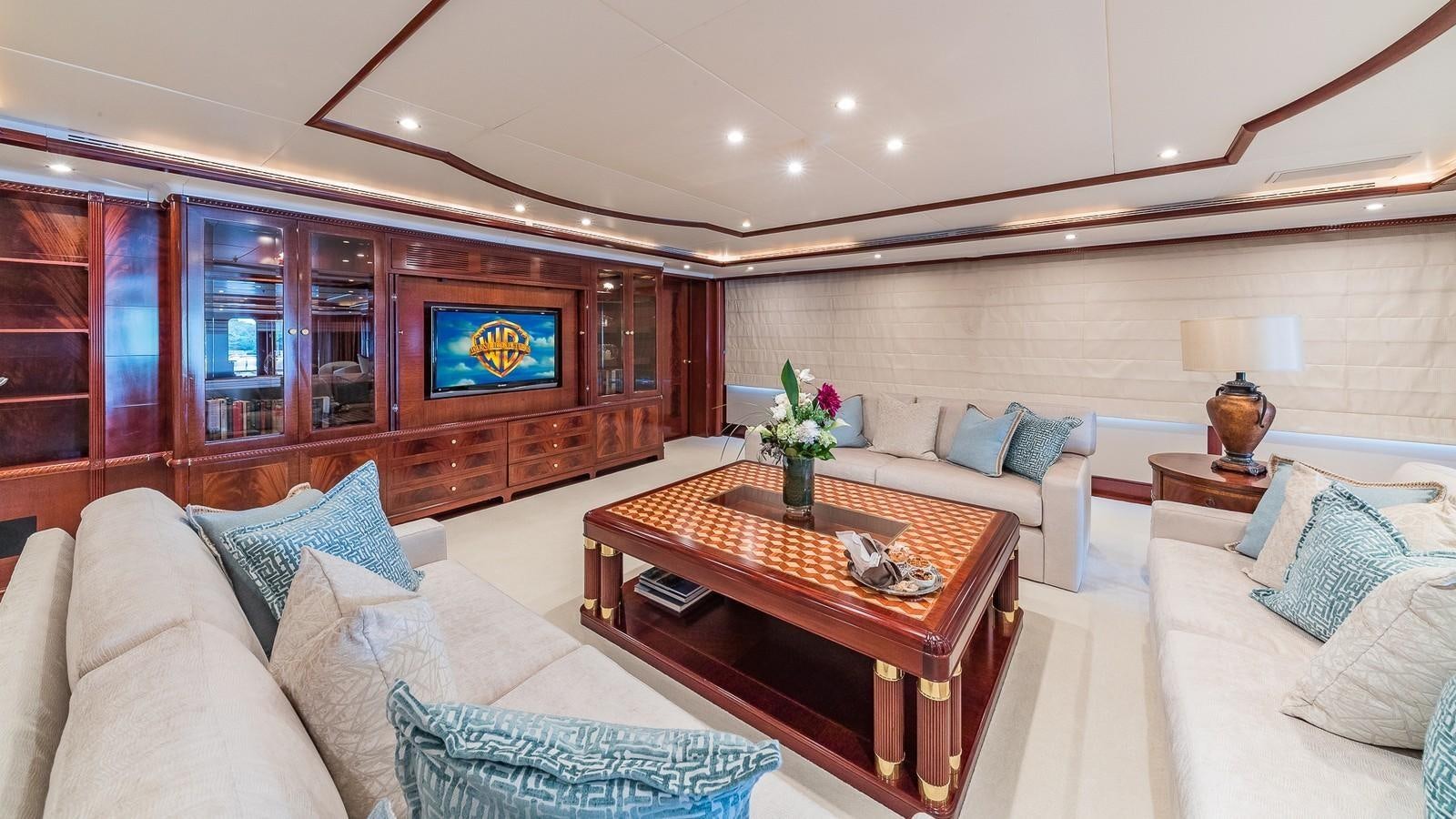 a living room with a table and couches aboard BELLA Yacht for Sale