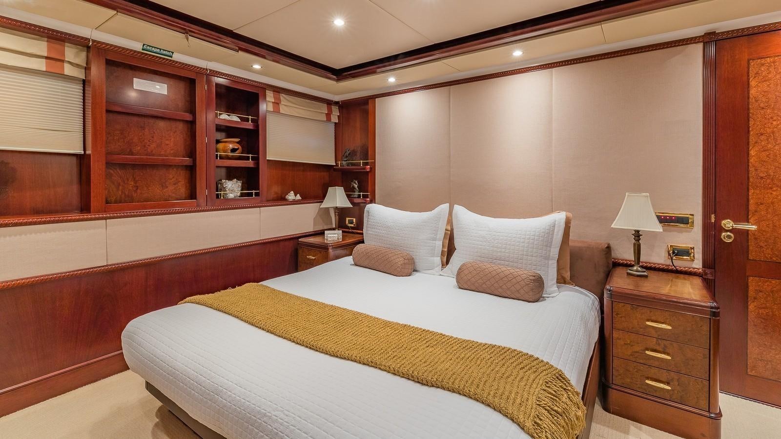a bedroom with a bed and a desk aboard BELLA Yacht for Sale