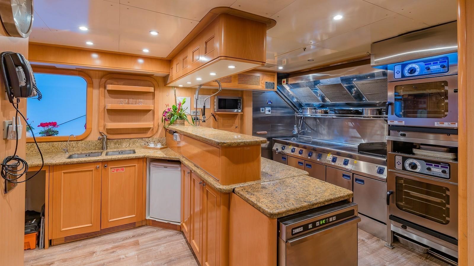 a kitchen with wooden cabinets aboard BELLA Yacht for Sale