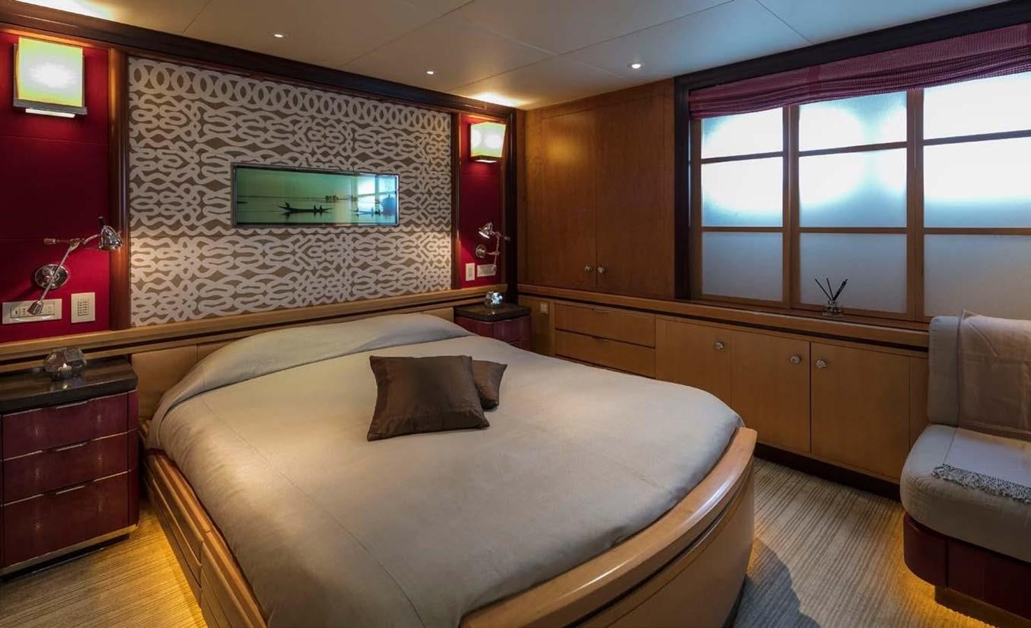 a bedroom with a bed and a chair aboard PEGASUS Yacht for Sale