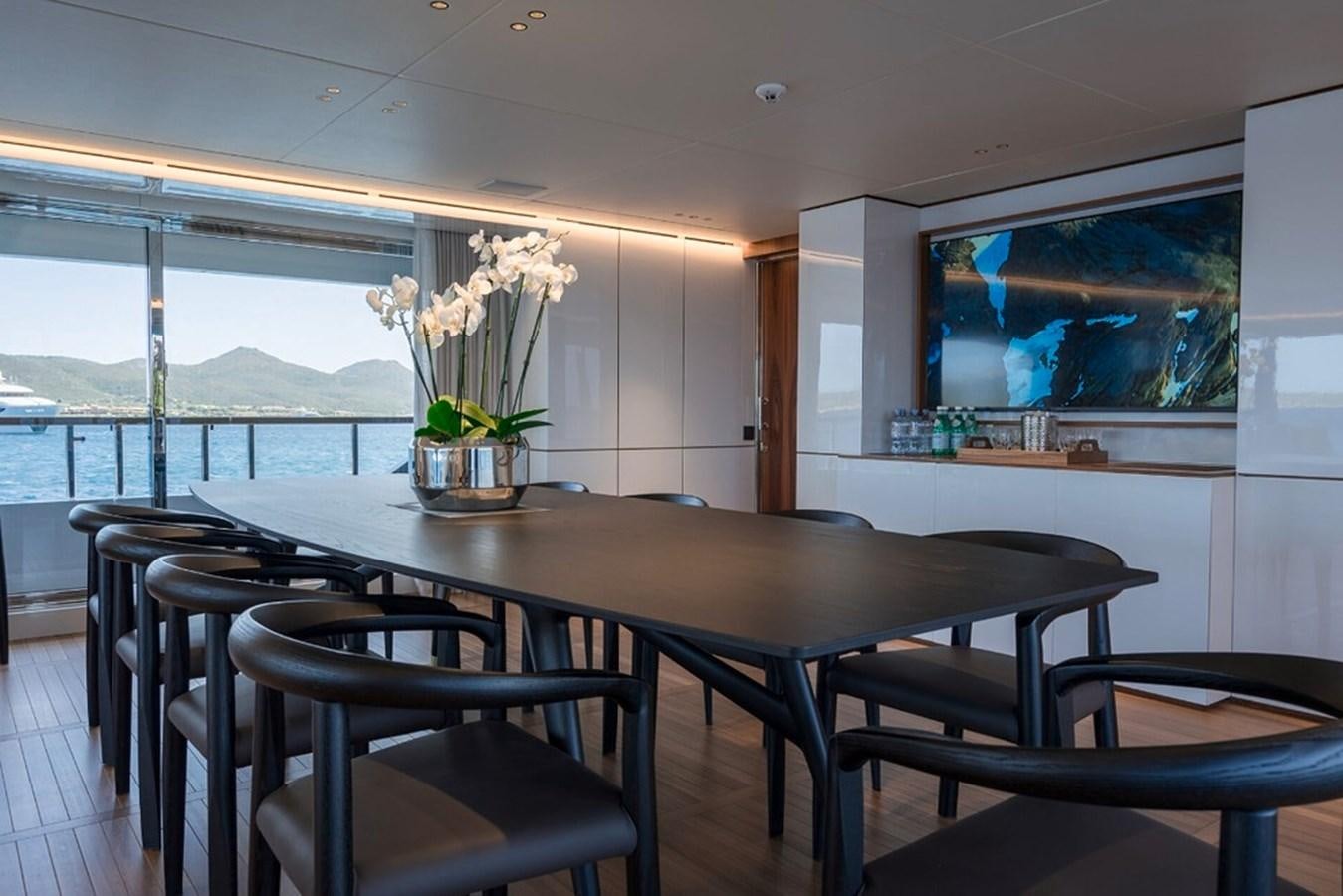 a table with chairs and a tv aboard TOSUN Yacht for Sale