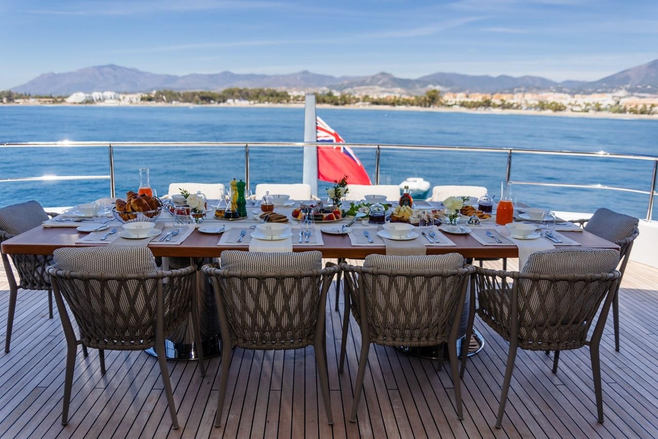 a table set for a meal on a deck overlooking the ocean aboard TOSUN Yacht for Sale