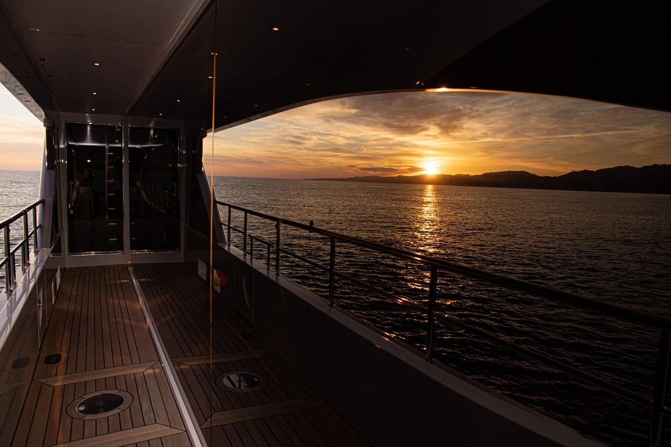 a dock leading to a sunset aboard TOSUN Yacht for Sale