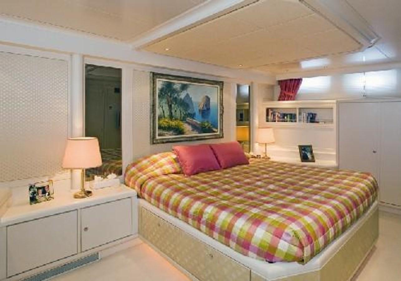 a bedroom with a bed and a painting on the wall aboard MATHILDA I Yacht for Sale