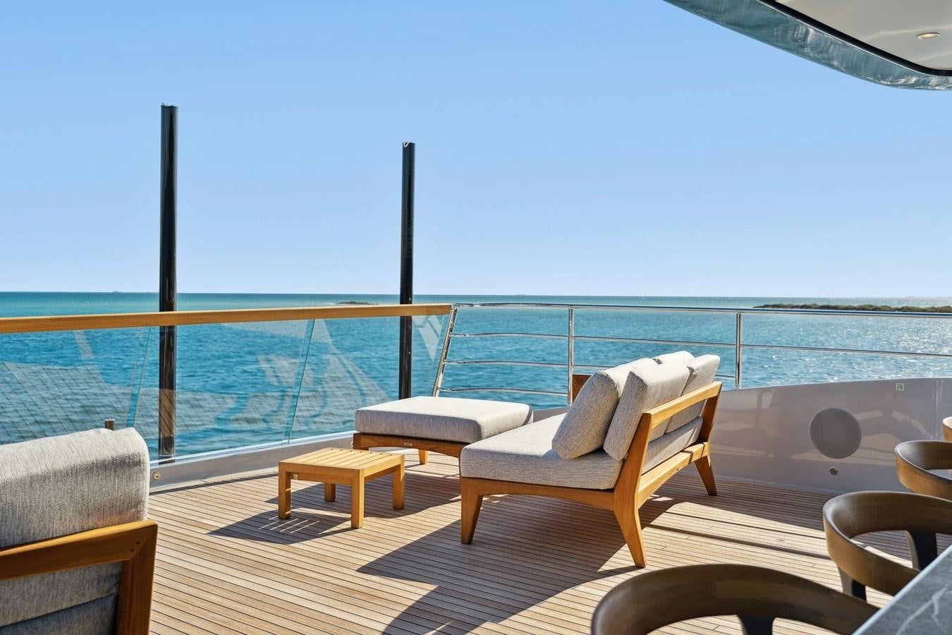 a deck with chairs and a body of water aboard GLOBAS Yacht for Sale