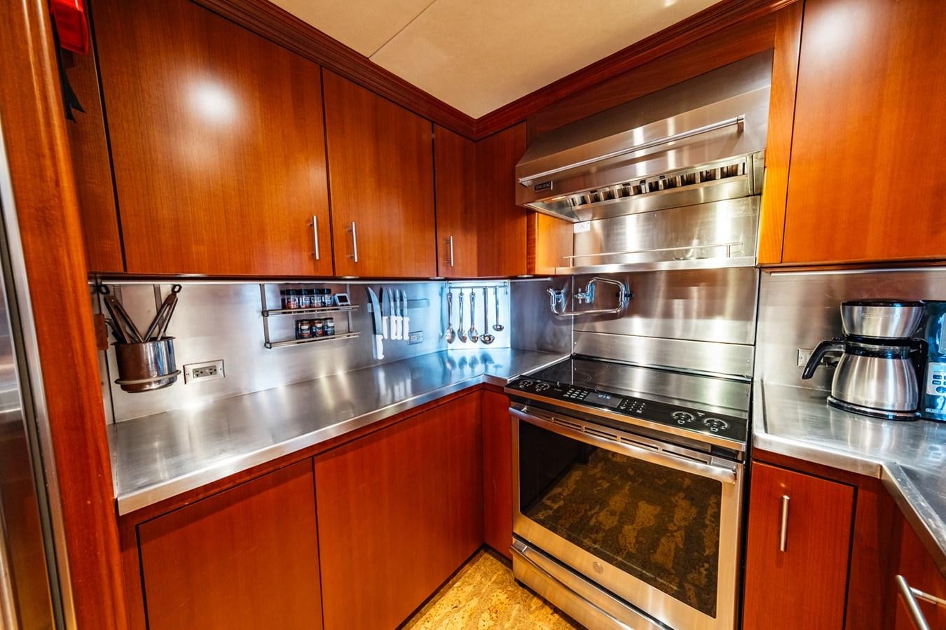 a kitchen with wooden cabinets aboard IMPETUOUS Yacht for Sale