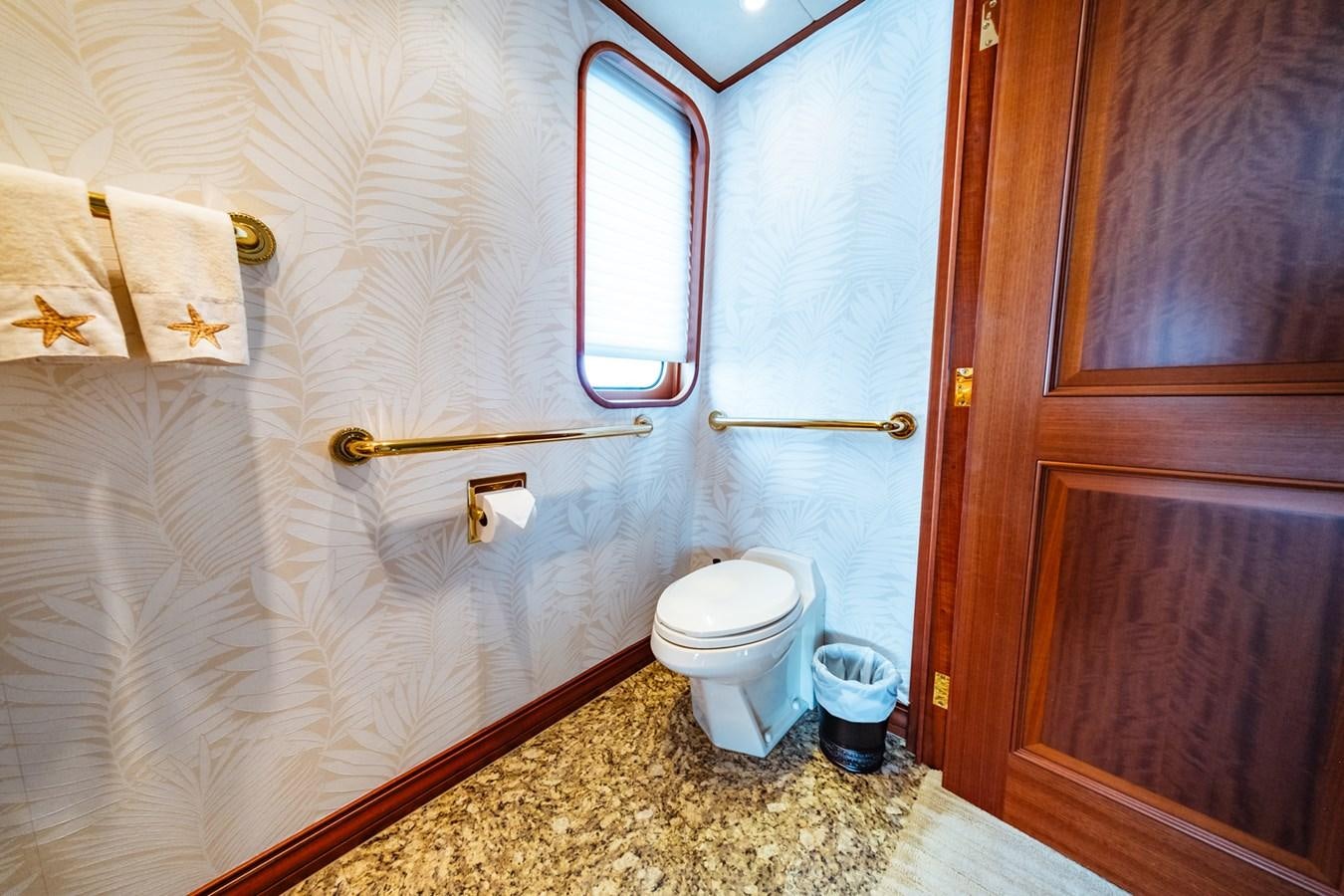 a bathroom with a toilet and a window aboard IMPETUOUS Yacht for Sale