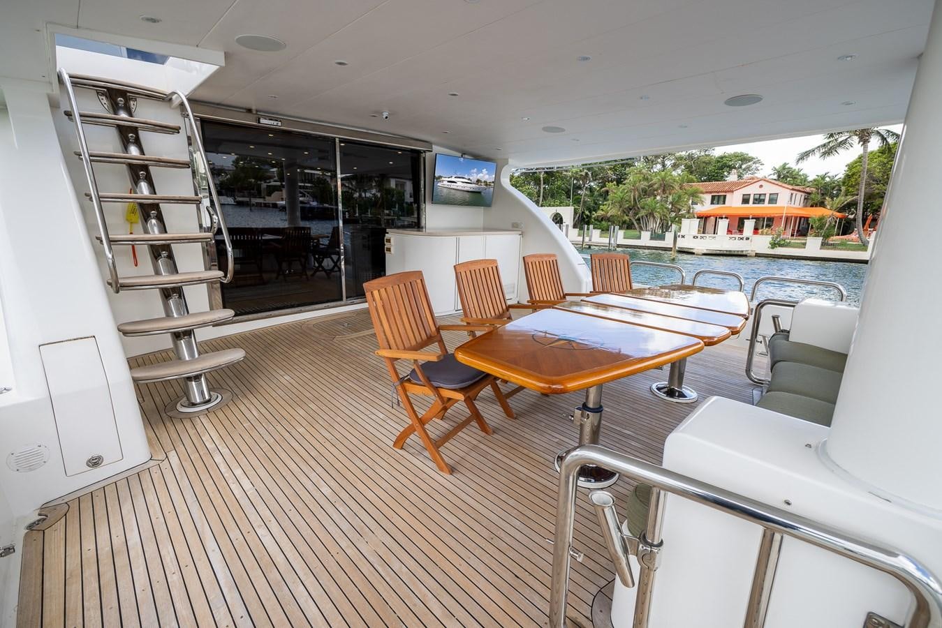 a room with a table chairs and a shelf with books on it aboard OCEAN 1 Yacht for Sale