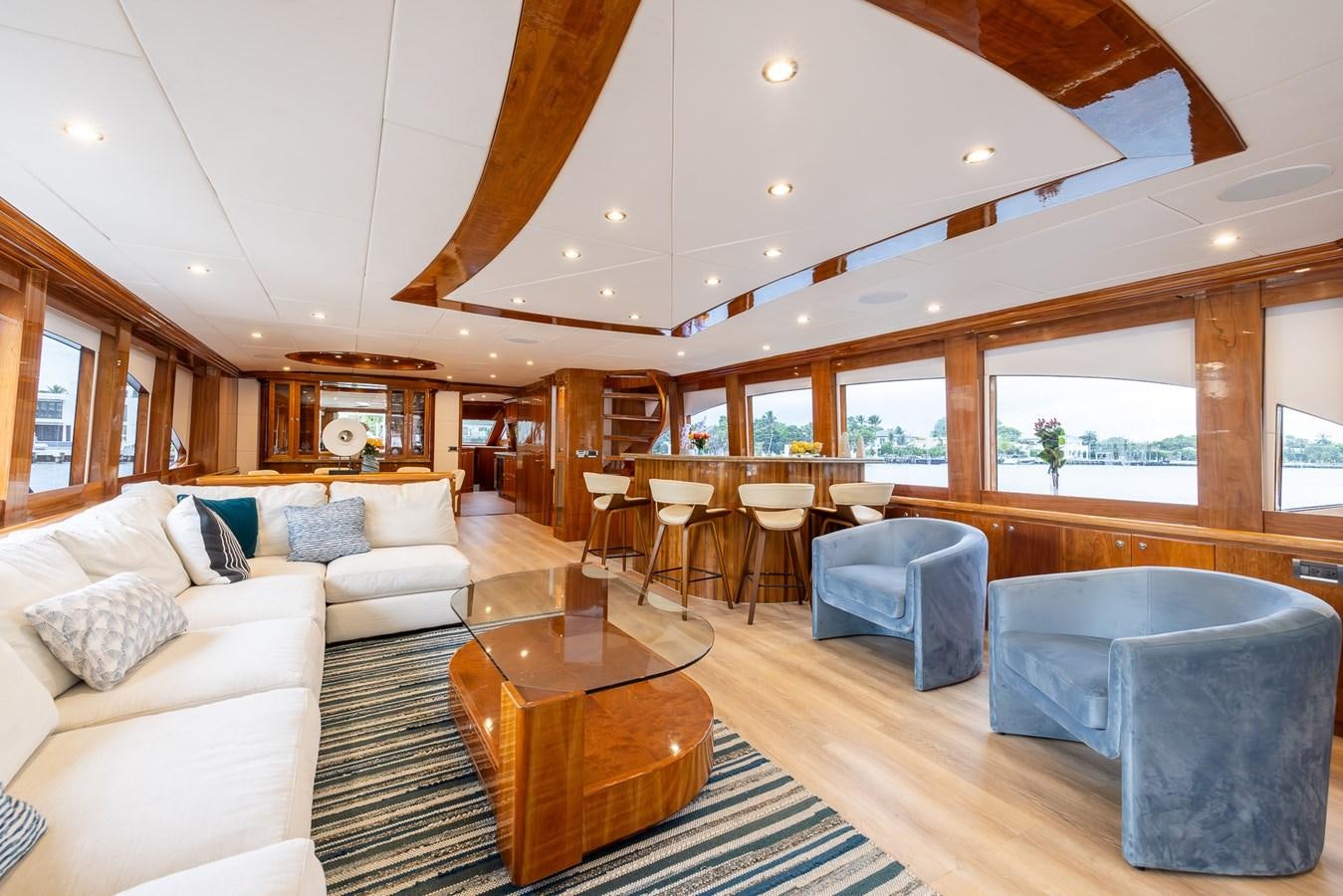 a living room with a large wood table and chairs aboard OCEAN 1 Yacht for Sale