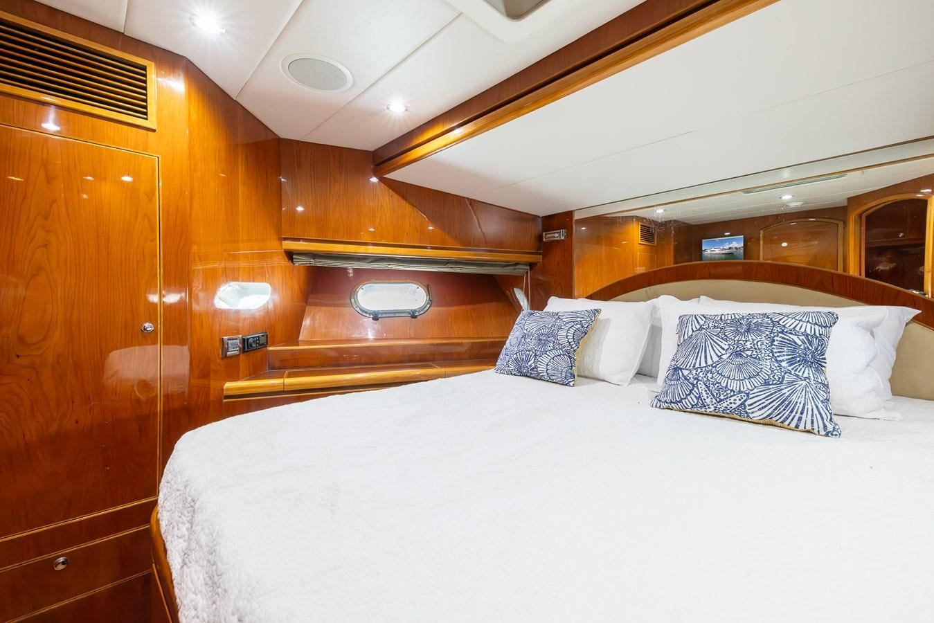 a bed with pillows and a wooden cabinet aboard OCEAN 1 Yacht for Sale