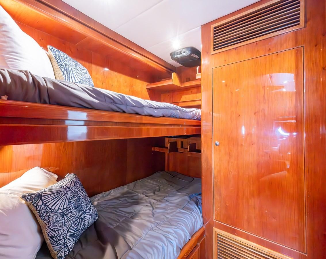 a bed with a wooden headboard aboard OCEAN 1 Yacht for Sale