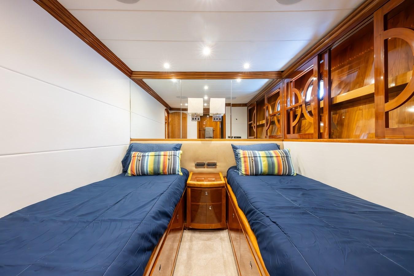 a room with beds and a wood table aboard OCEAN 1 Yacht for Sale