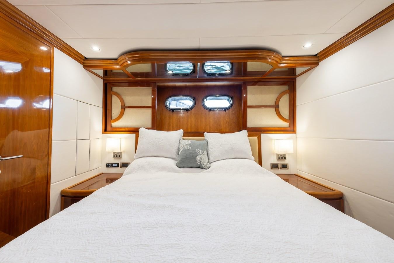 a bed with pillows and a mirror above it aboard OCEAN 1 Yacht for Sale