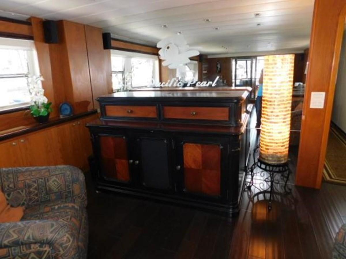 a living room with a fireplace aboard PACIFIC PEARL Yacht for Sale