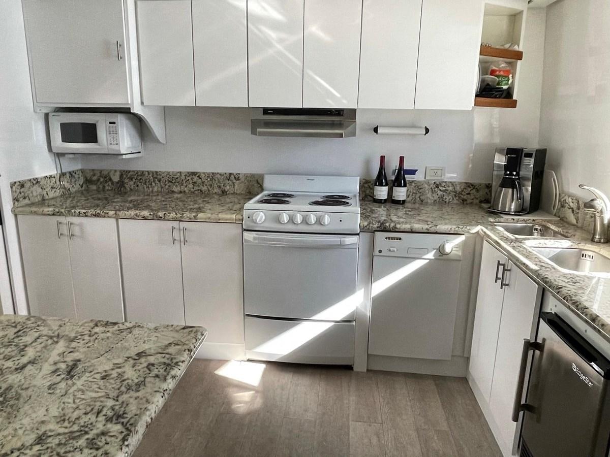 a kitchen with white cabinets aboard PACIFIC PEARL Yacht for Sale