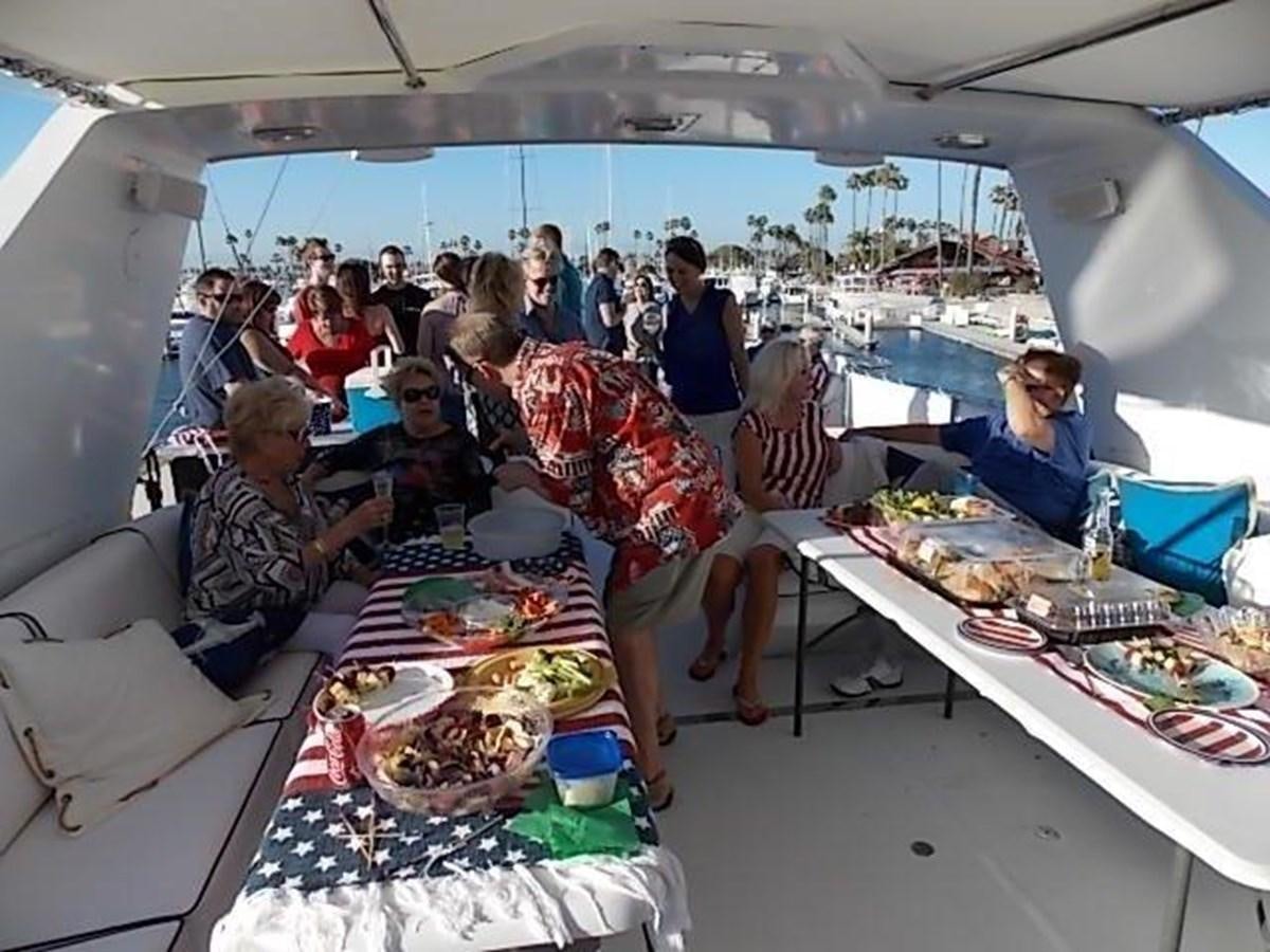 a group of people sitting at a table eating food aboard PACIFIC PEARL Yacht for Sale