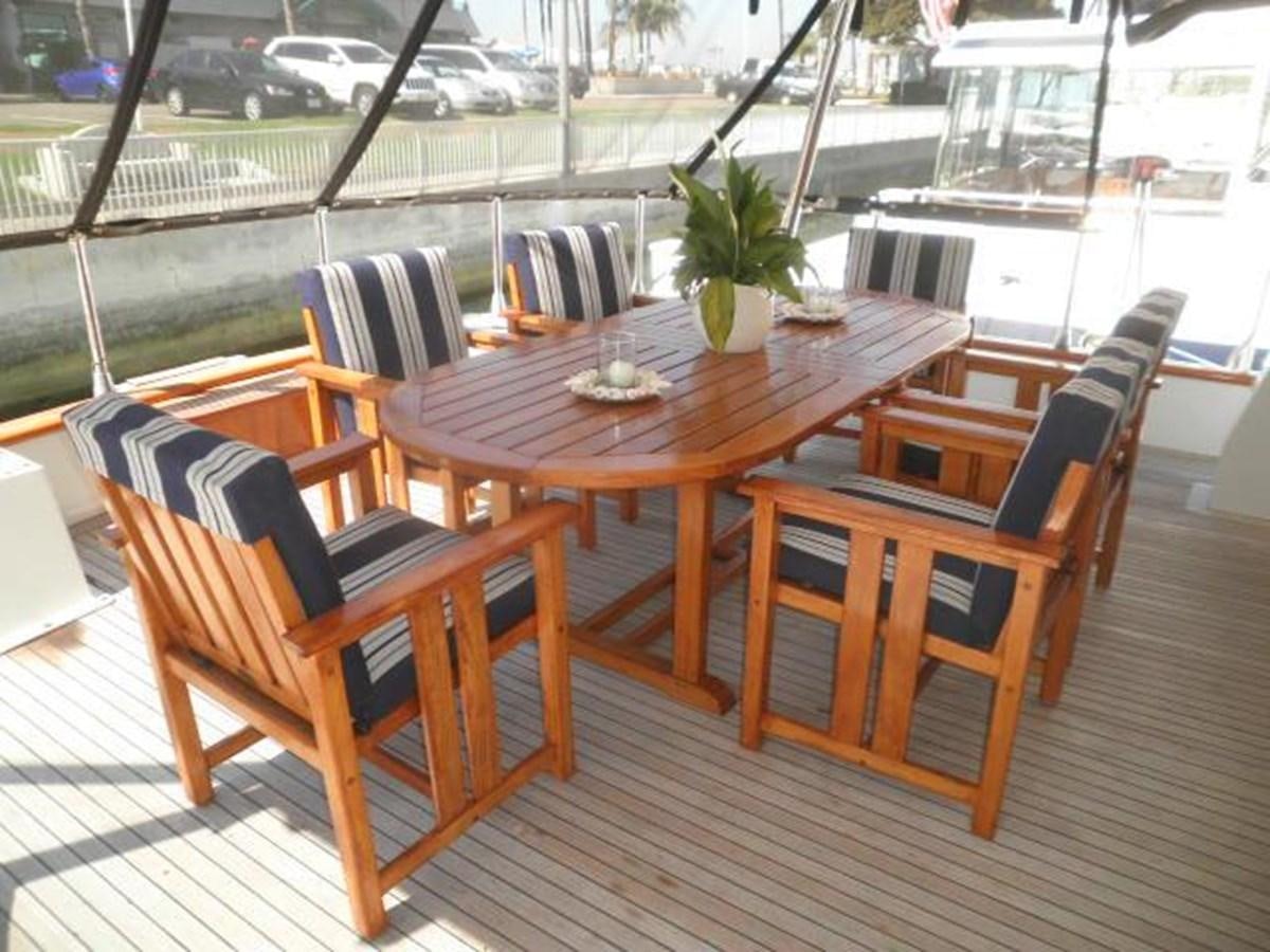 a table with chairs around it aboard PACIFIC PEARL Yacht for Sale