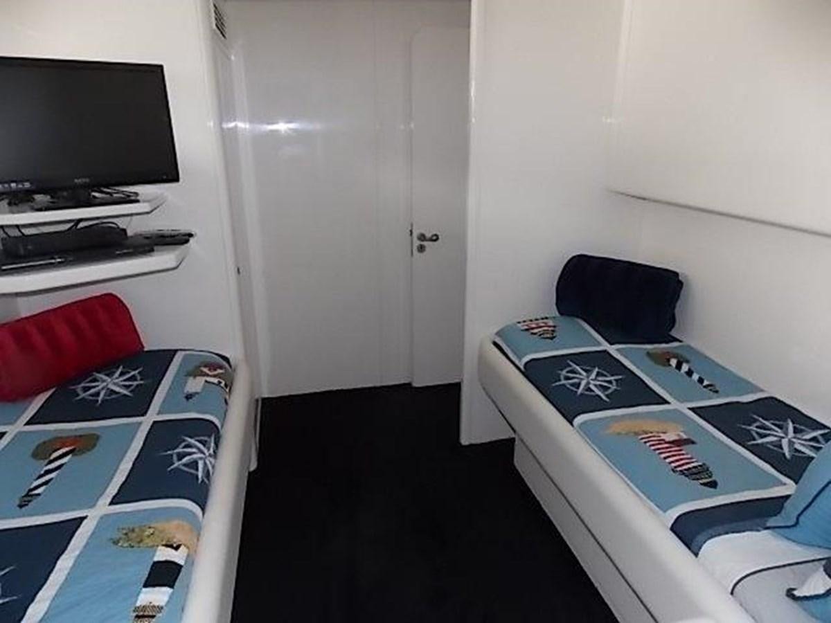 a room with a bed and a television aboard PACIFIC PEARL Yacht for Sale