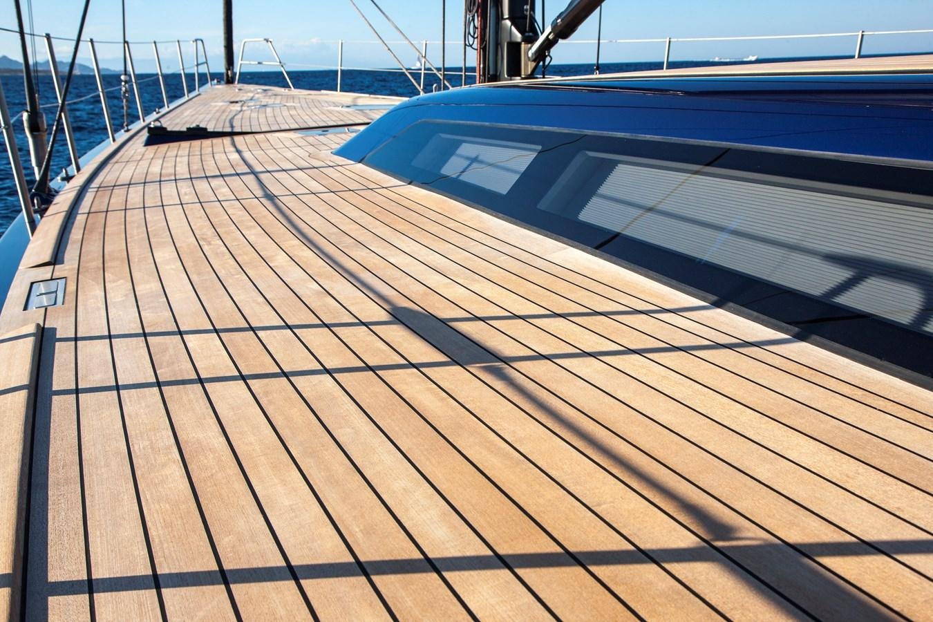 a wooden deck with a railing aboard INTI CUBE Yacht for Sale