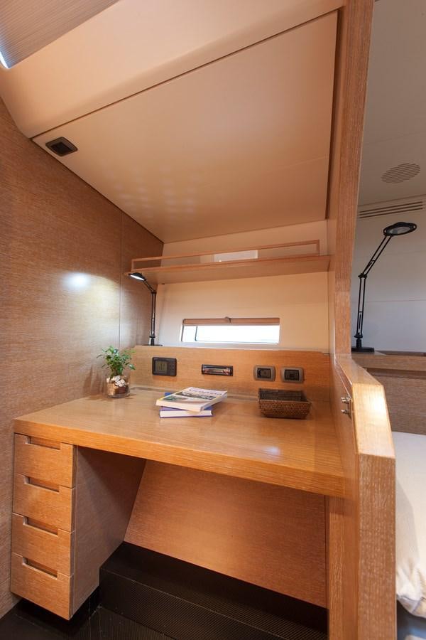 a wooden desk with a lamp and books on it aboard INTI CUBE Yacht for Sale