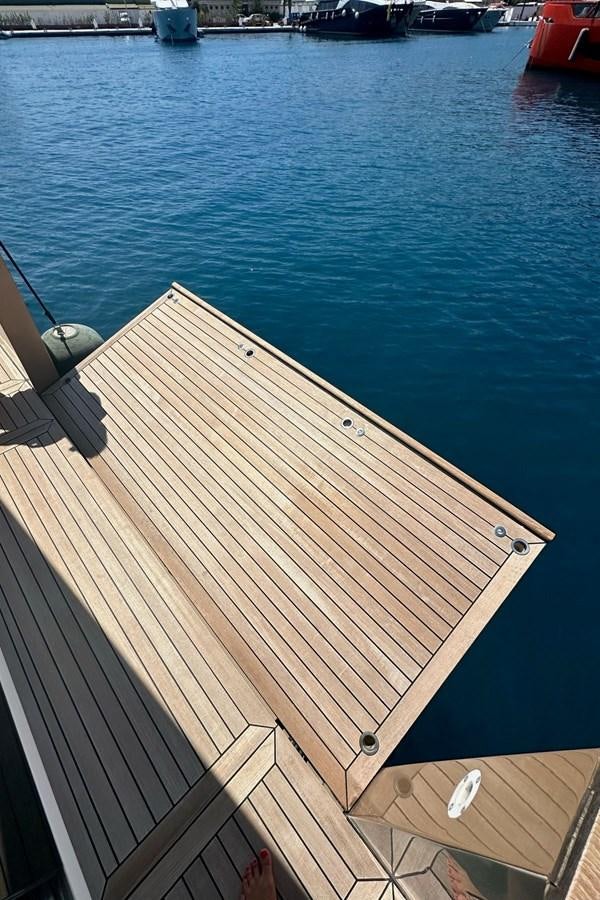 a deck with a railing and a body of water in the background aboard REKOMA Yacht for Sale
