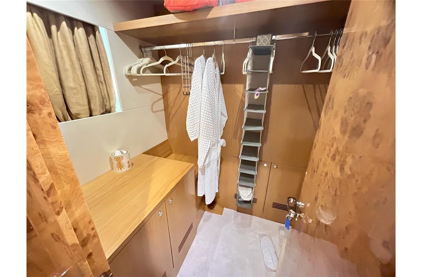a room with a table and a shelf with clothes on it aboard 888 Yacht for Sale