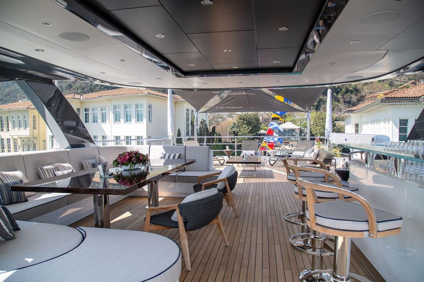 a deck with tables and chairs aboard STARBURST III Yacht for Sale