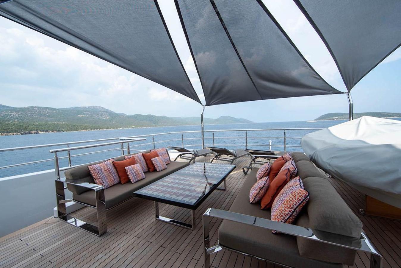 a patio with a couch and a table on it aboard STARBURST III Yacht for Sale