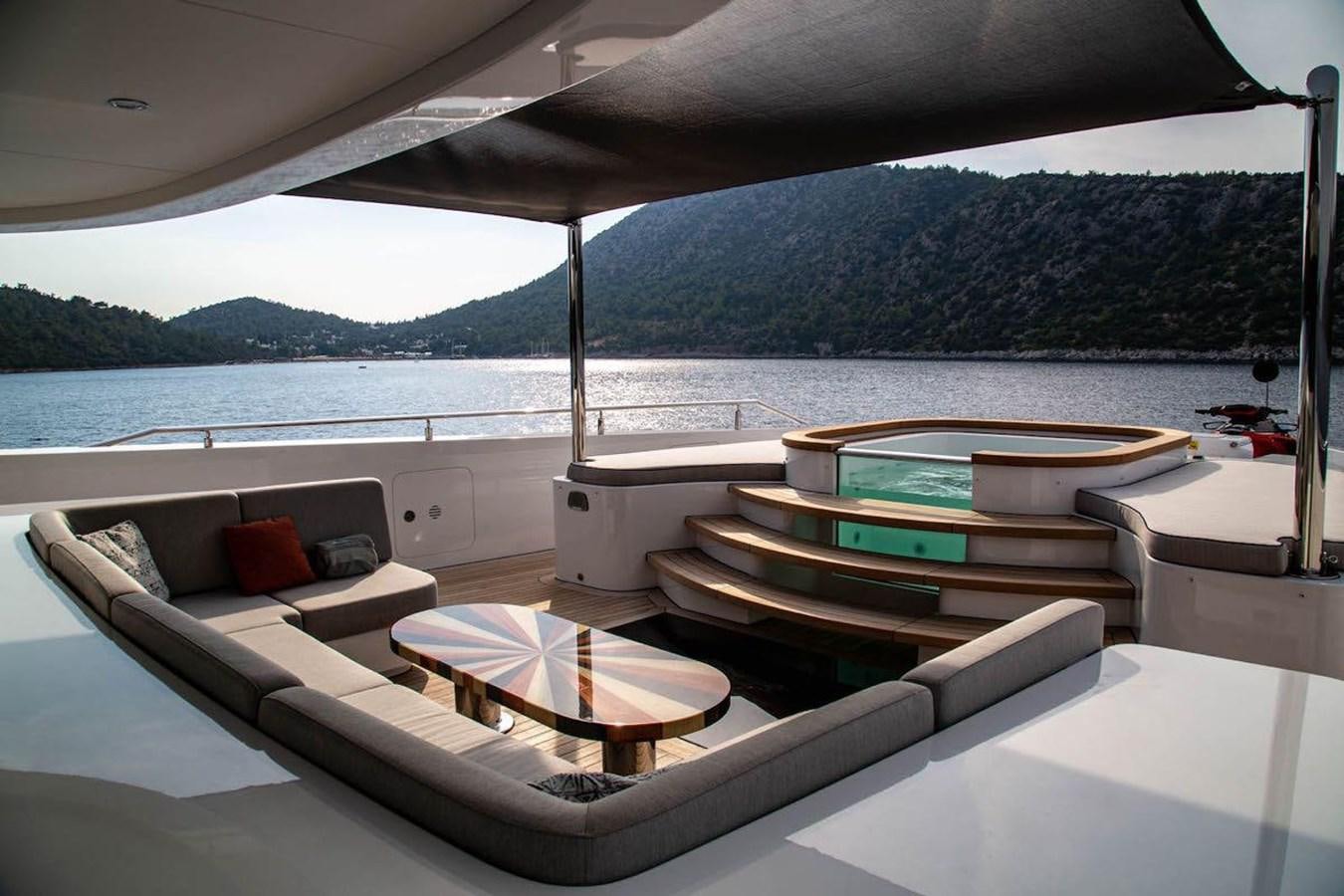 a lounge area with a large body of water in the background aboard STARBURST III Yacht for Sale