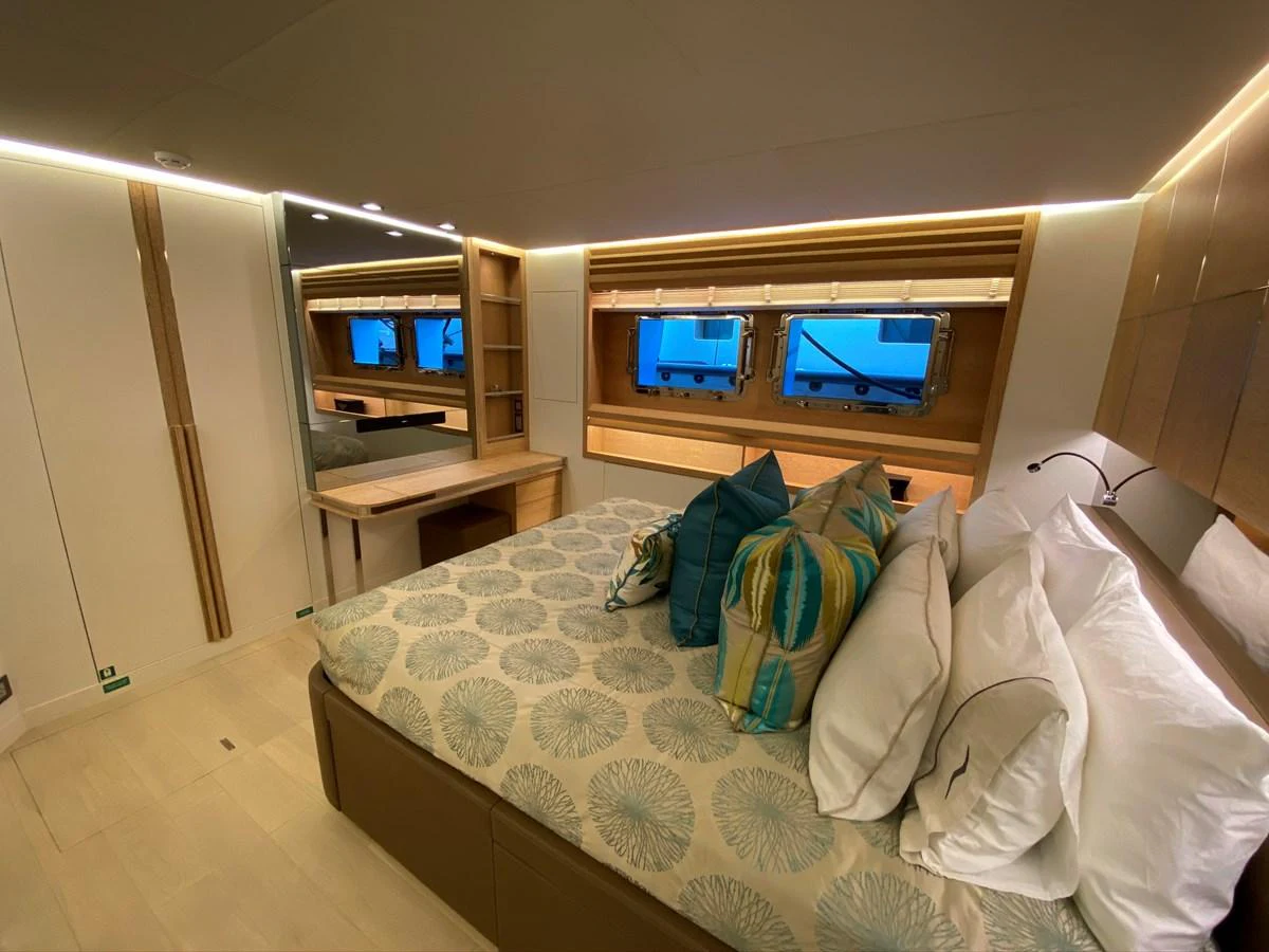 a bed with pillows and a television aboard PERSISTENCE Yacht for Sale