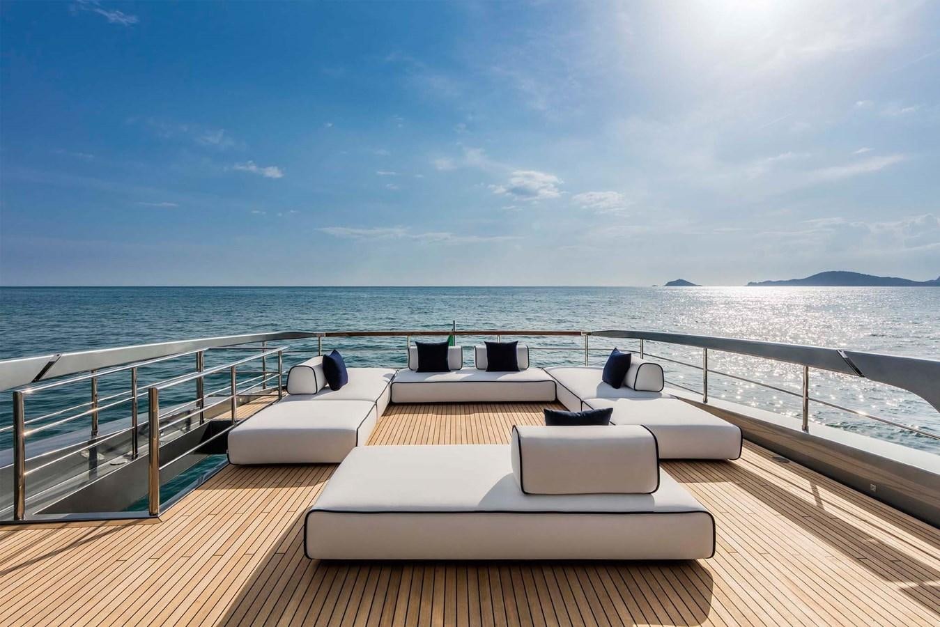a deck with chairs and a body of water in the background aboard TAKU Yacht for Sale