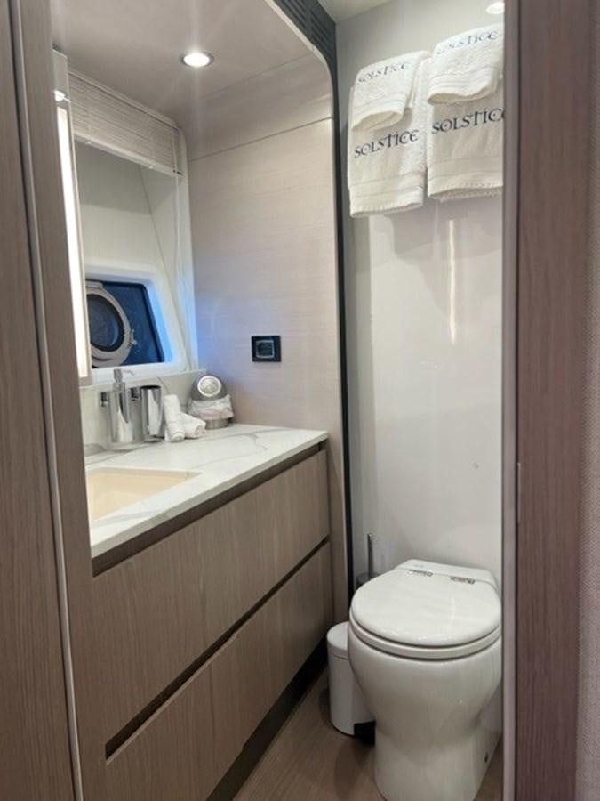 a bathroom with a toilet and a sink aboard SOLSTICE Yacht for Sale