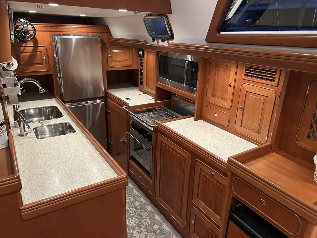 a kitchen with wooden cabinets aboard TRIUMPH Yacht for Sale