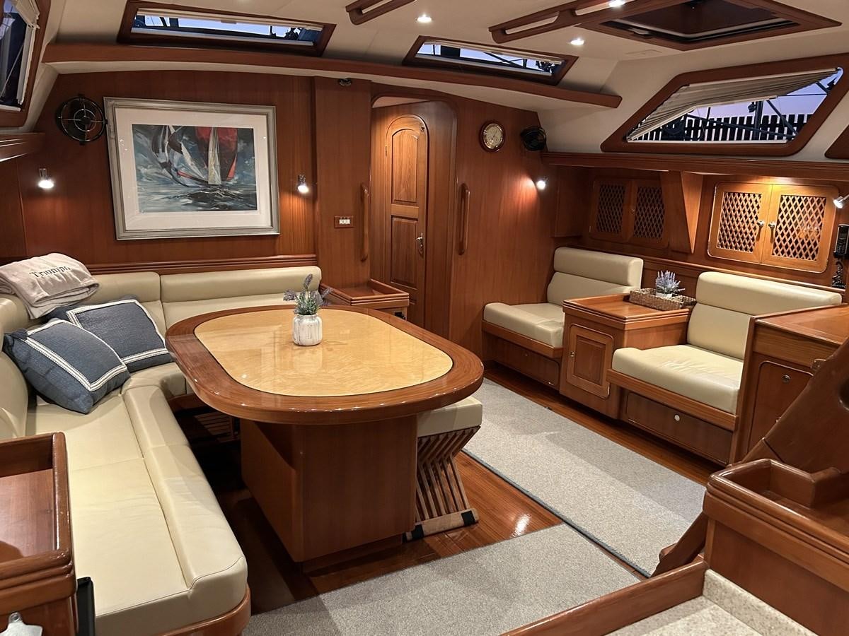 a living room with a table and couches aboard TRIUMPH Yacht for Sale