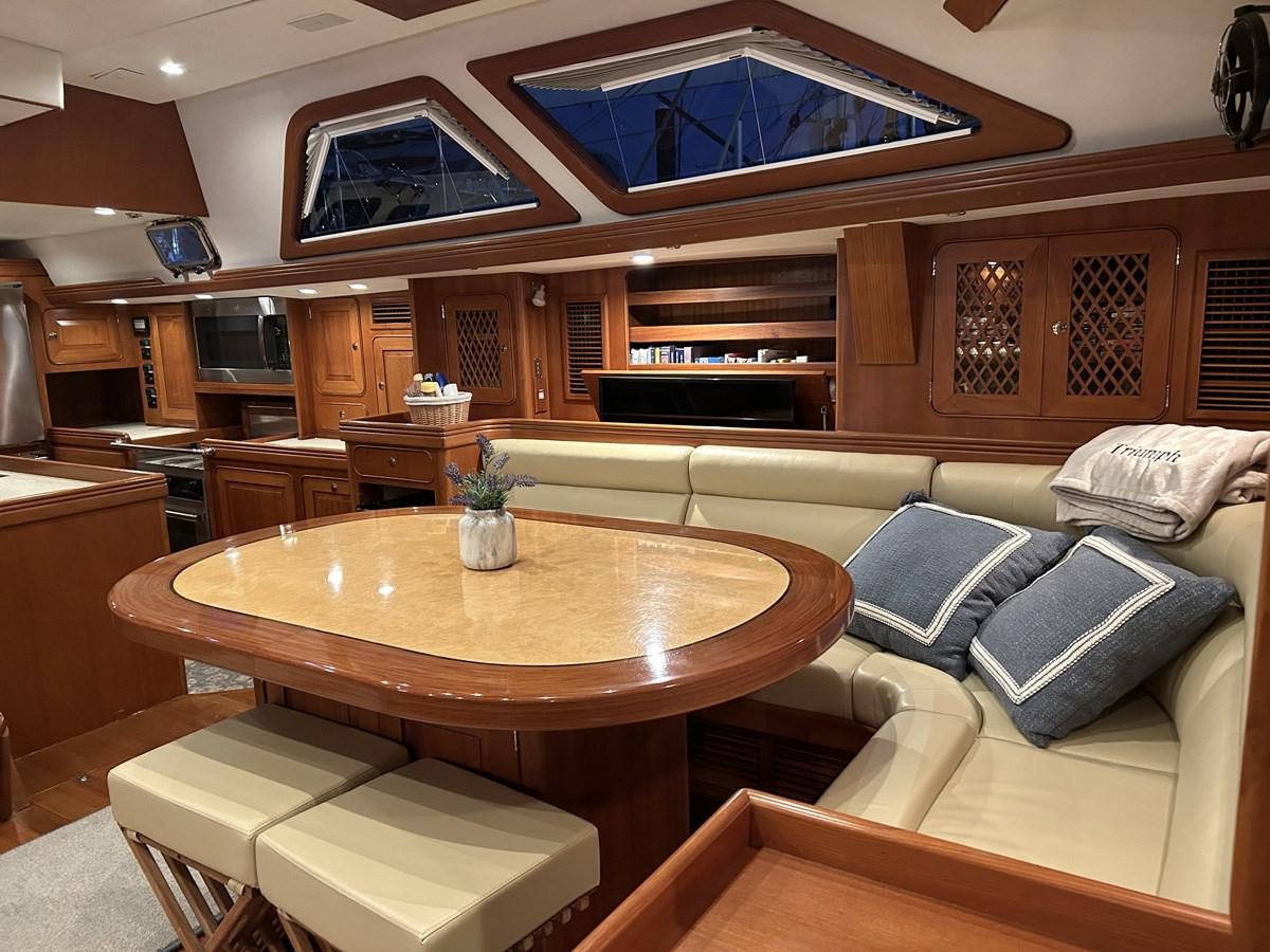 a living room with a table and couches aboard TRIUMPH Yacht for Sale