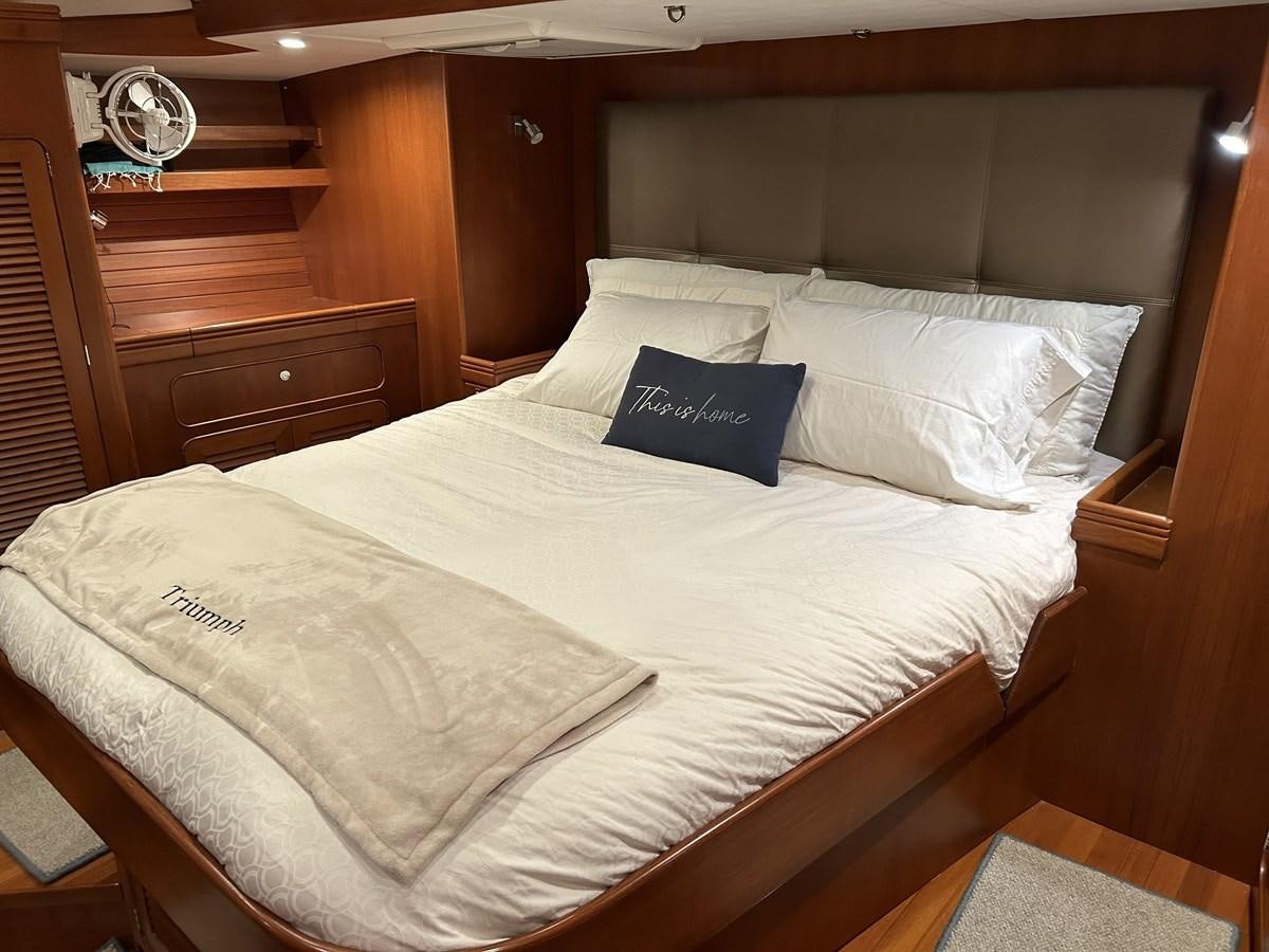 a bed with white sheets and pillows aboard TRIUMPH Yacht for Sale