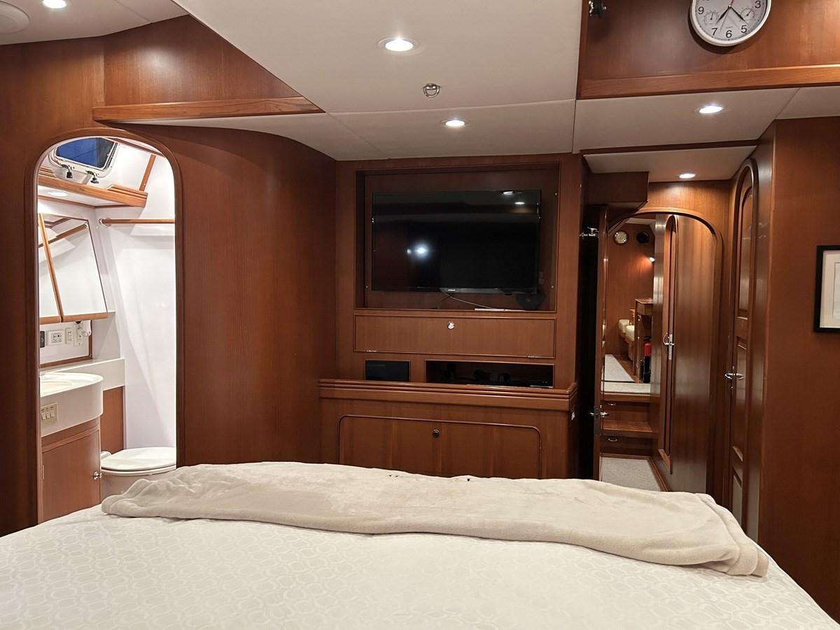 a bedroom with a bed and a television aboard TRIUMPH Yacht for Sale