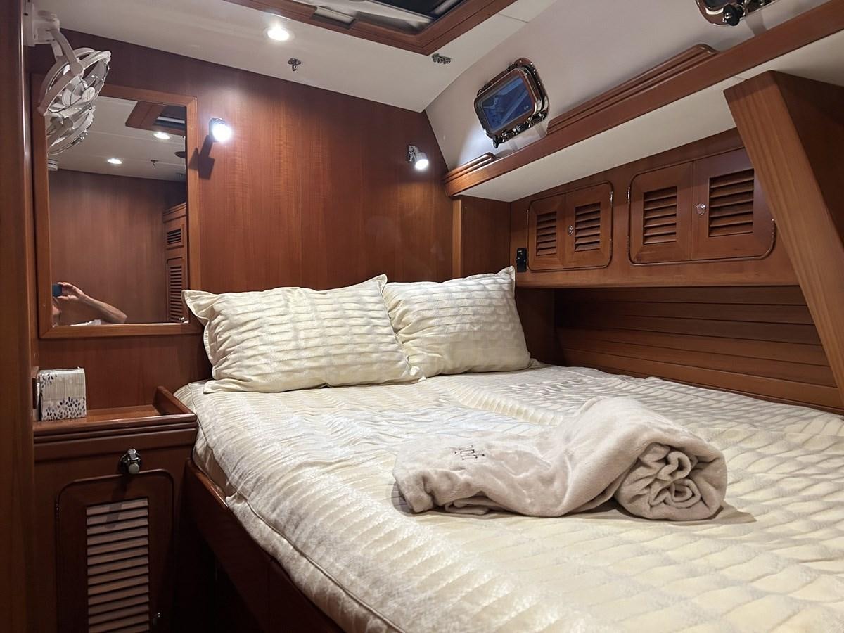 a bed with a white sheet and pillows aboard TRIUMPH Yacht for Sale