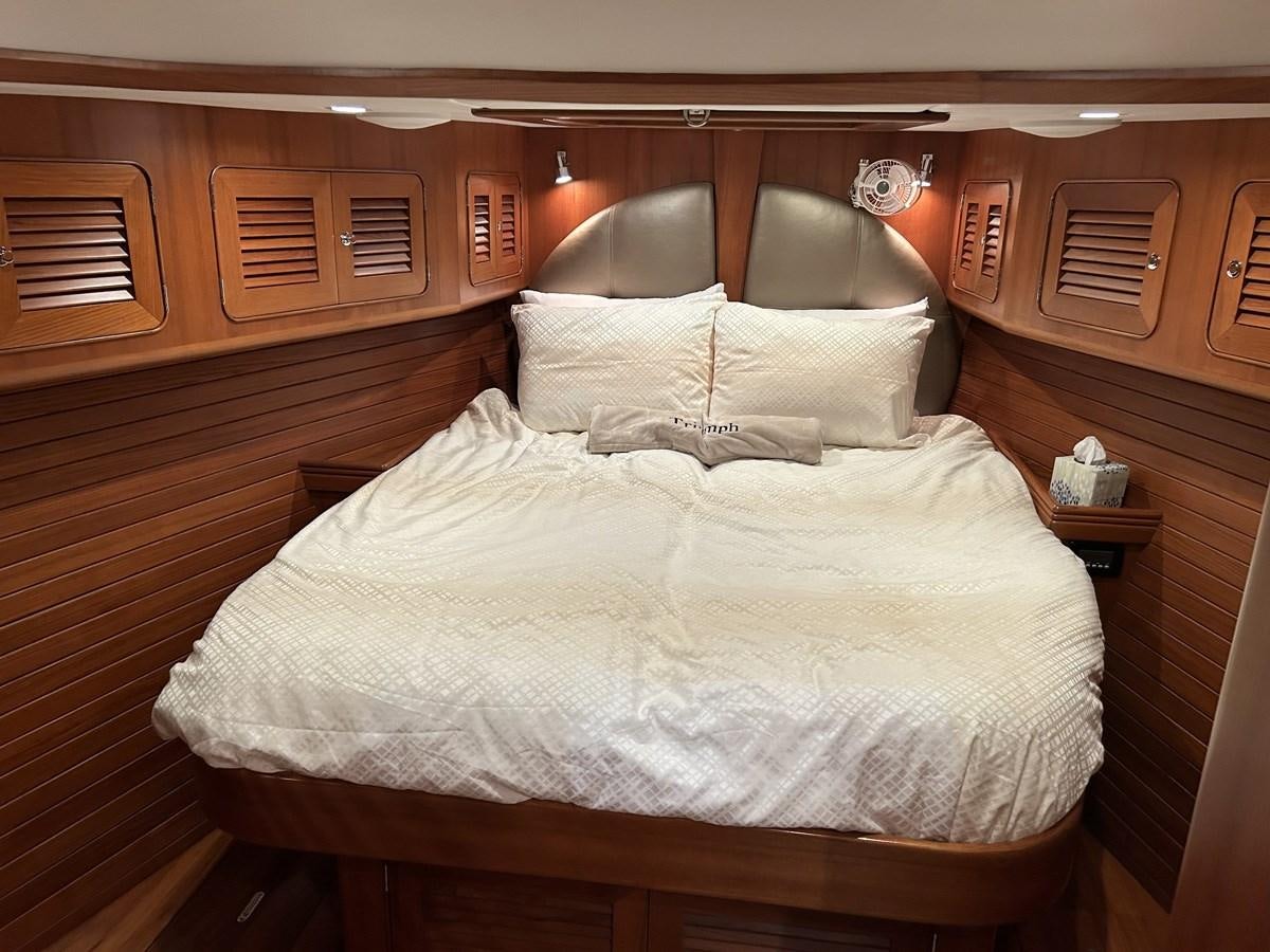 a bed with white sheets aboard TRIUMPH Yacht for Sale