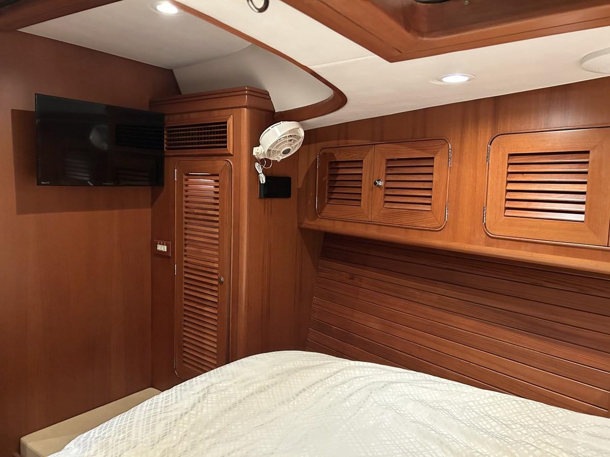 a room with a bed and a television aboard TRIUMPH Yacht for Sale