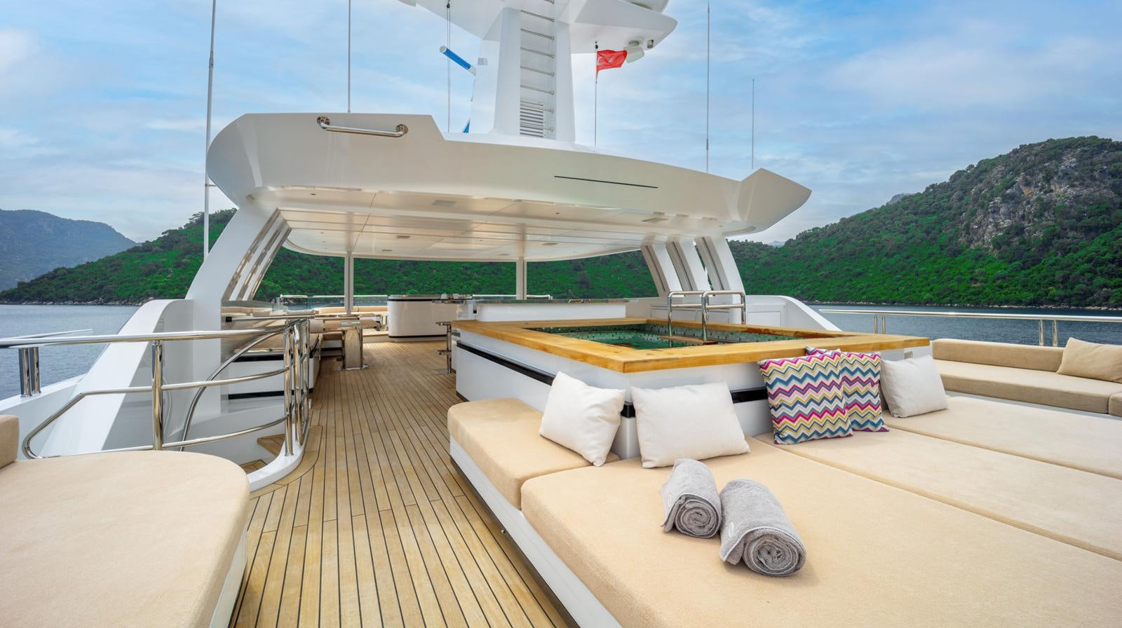 a deck with a large bed and a large white boat on it aboard M 47 Yacht for Sale