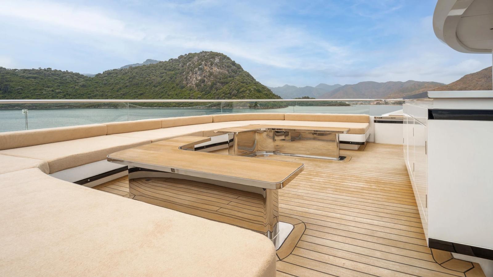 a deck with a view of the ocean and mountains aboard M 47 Yacht for Sale