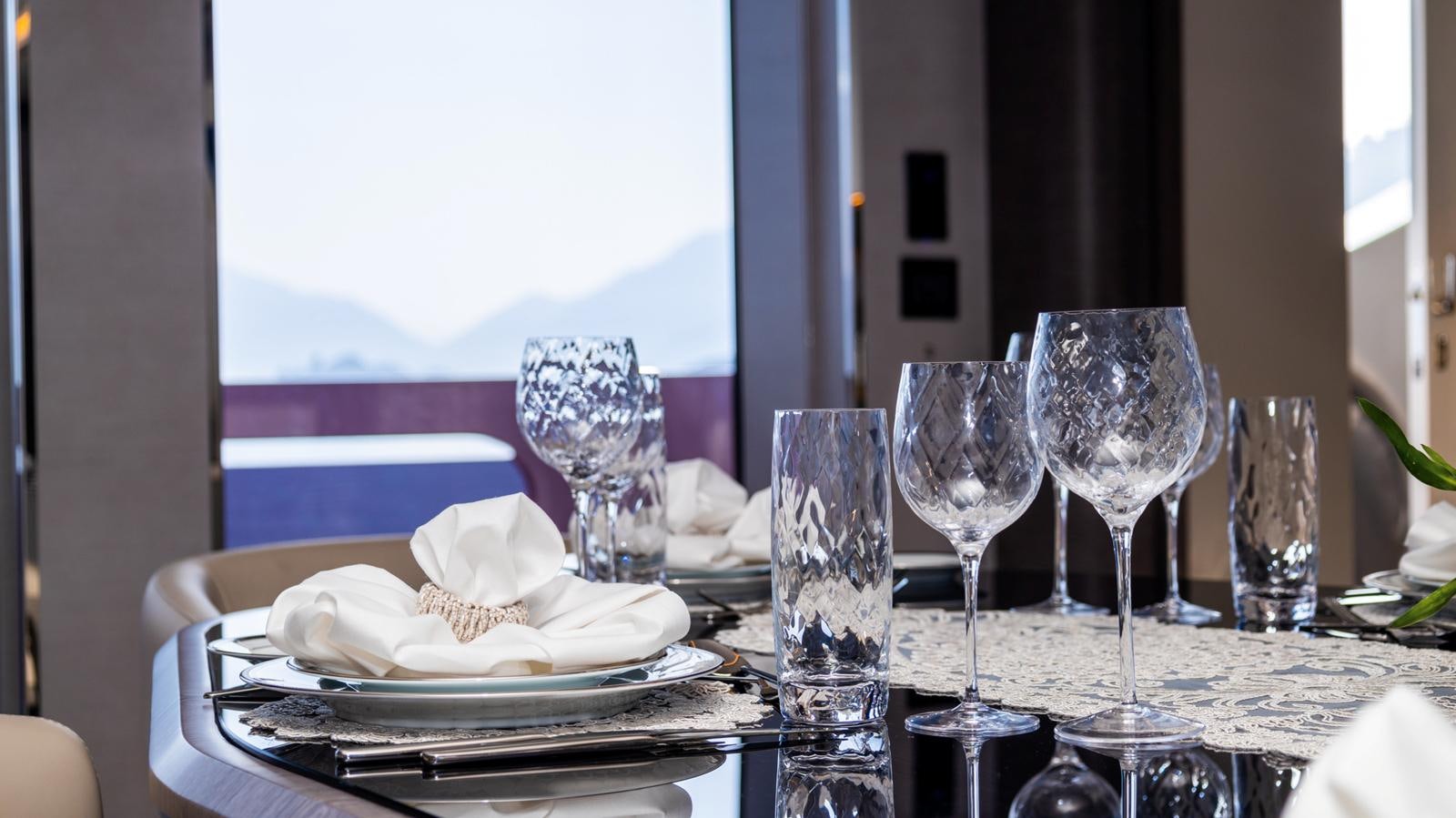 a table with wine glasses and a plate of food on it aboard M 47 Yacht for Sale
