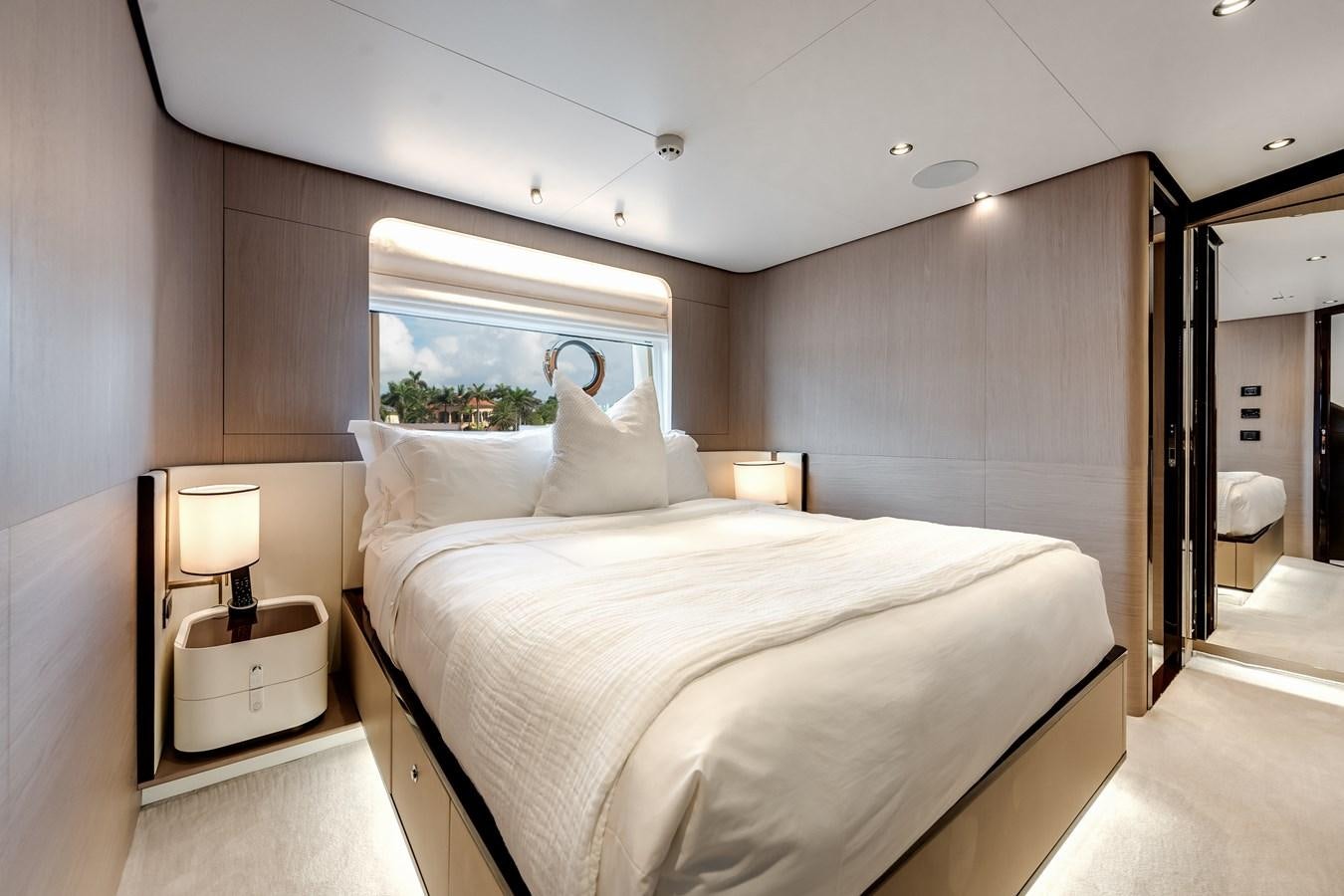 a bedroom with a bed and a lamp aboard DAYBREAK Yacht for Sale