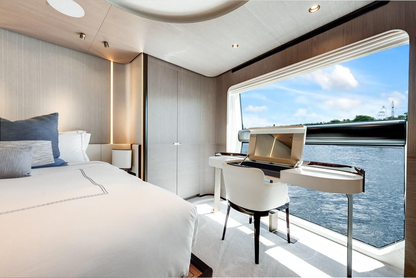 a room with a bed and a table and a window aboard DAYBREAK Yacht for Sale