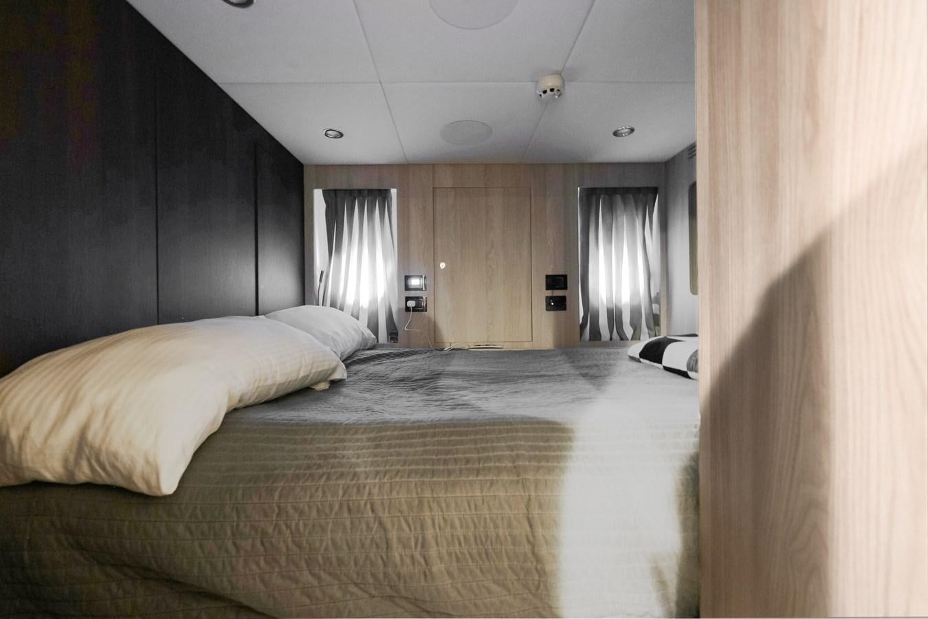 a bed with a lamp on it aboard DAYBREAK Yacht for Sale