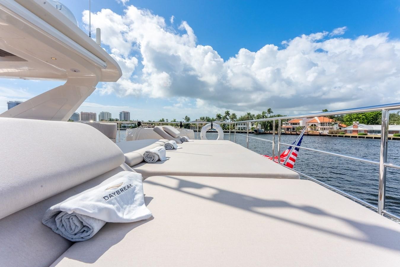 a pair of white shoes on a deck overlooking a beach aboard DAYBREAK Yacht for Sale