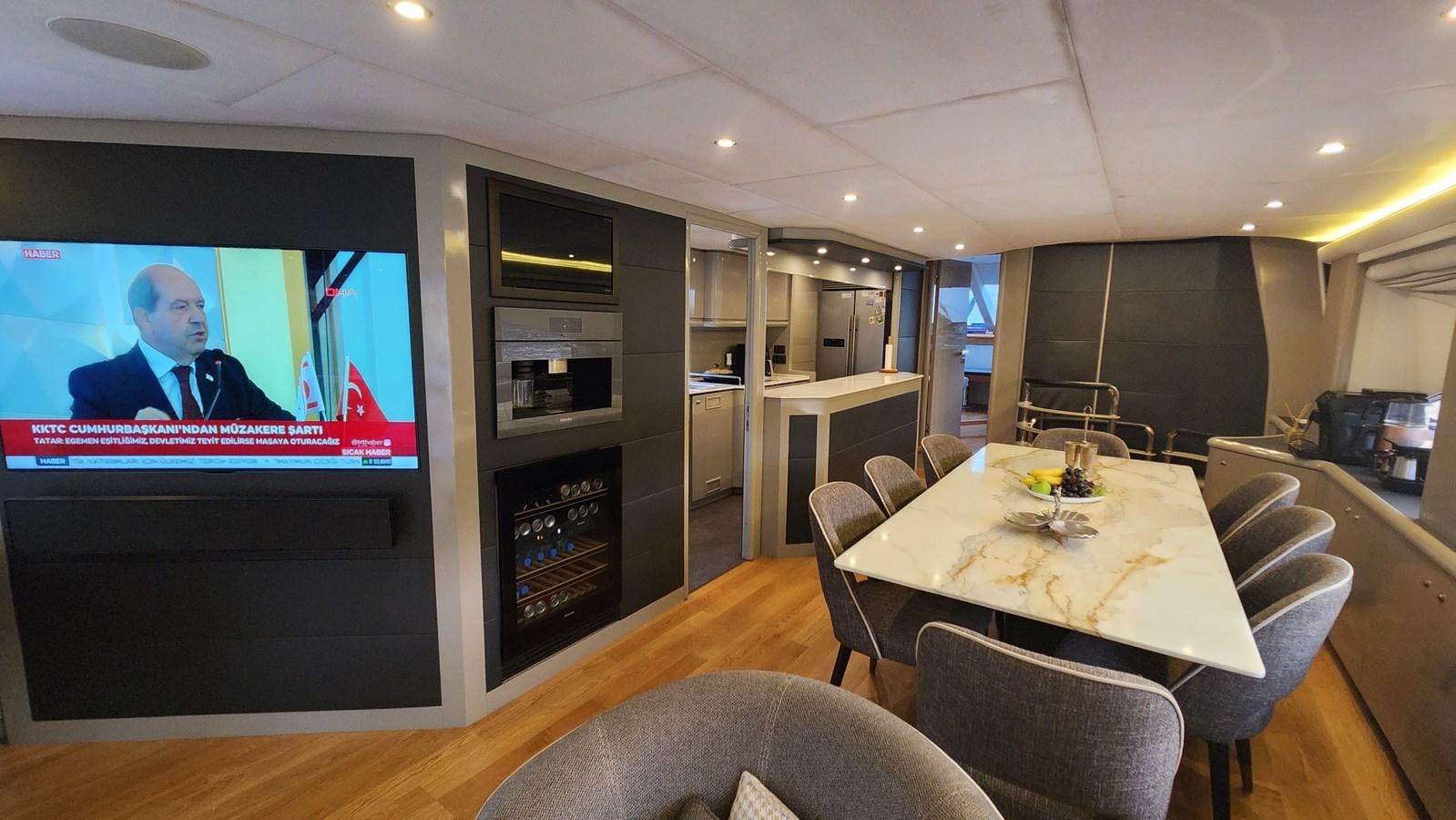 a large room with a table and chairs and a tv aboard SPACE ODDITY Yacht for Sale