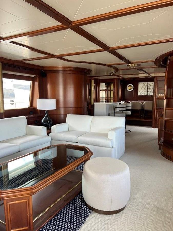 a living room with a table and couches aboard MYEERAH Yacht for Sale