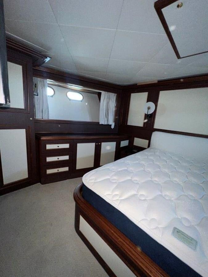 a room with a bed and a dresser aboard MYEERAH Yacht for Sale